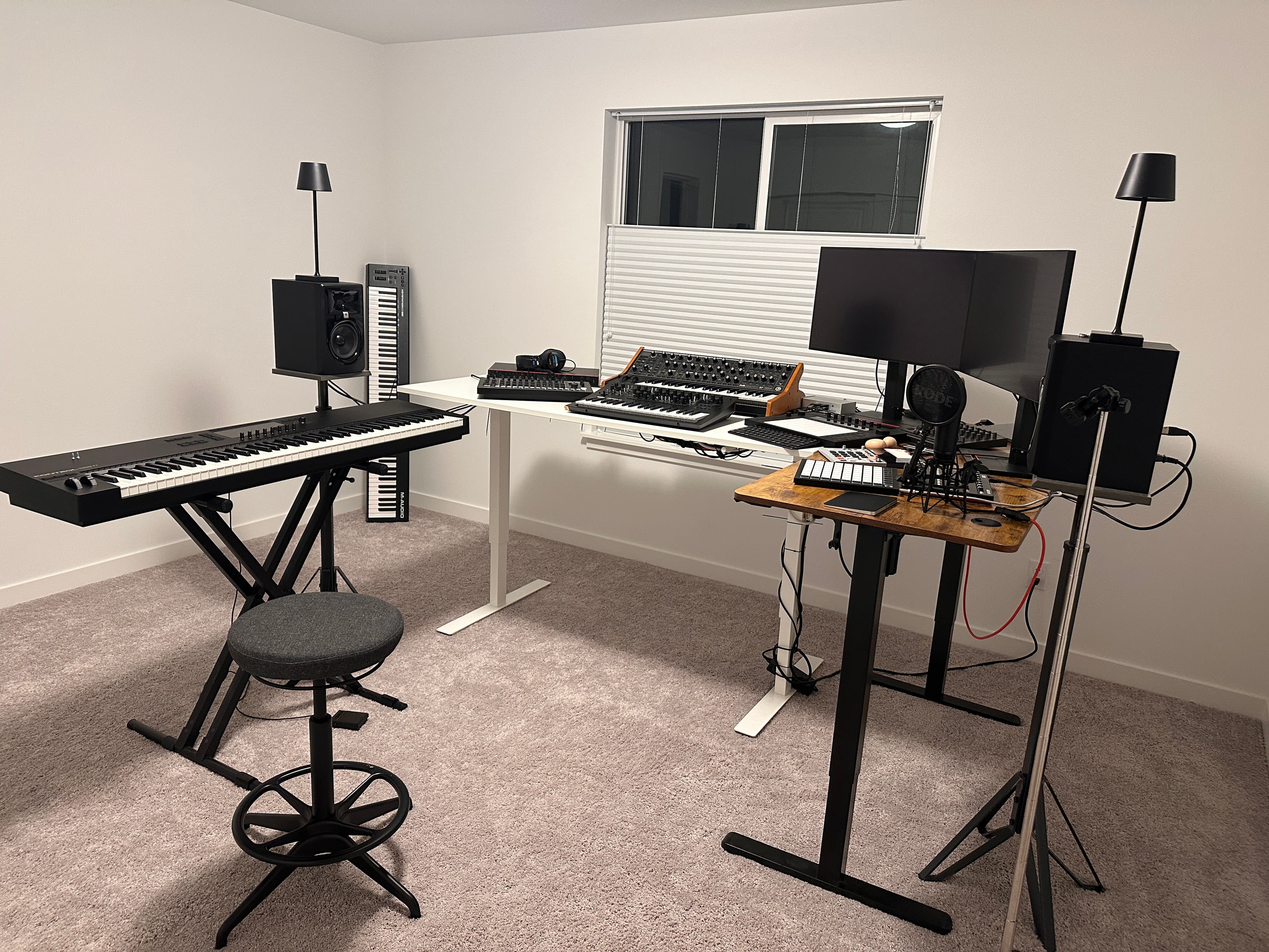 Studio setup with hardware synths, drum machines, and a focused mix position.